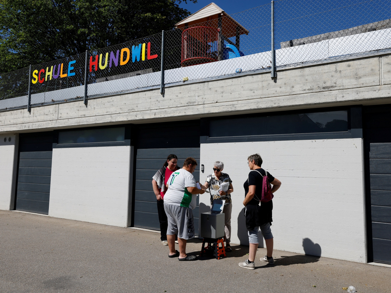 People vote in front of a school in the referendum put forward by the right-wing Swiss People's Party in Hundwil, Switzerland. Photo: Reuters