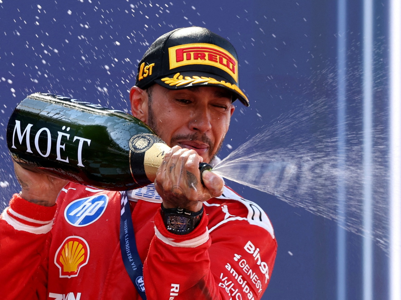 Ferrari's Lewis Hamilton celebrates on the podium with champagne after winning the Barcelona-Catalunya Grand Prix. Photo: Reuters