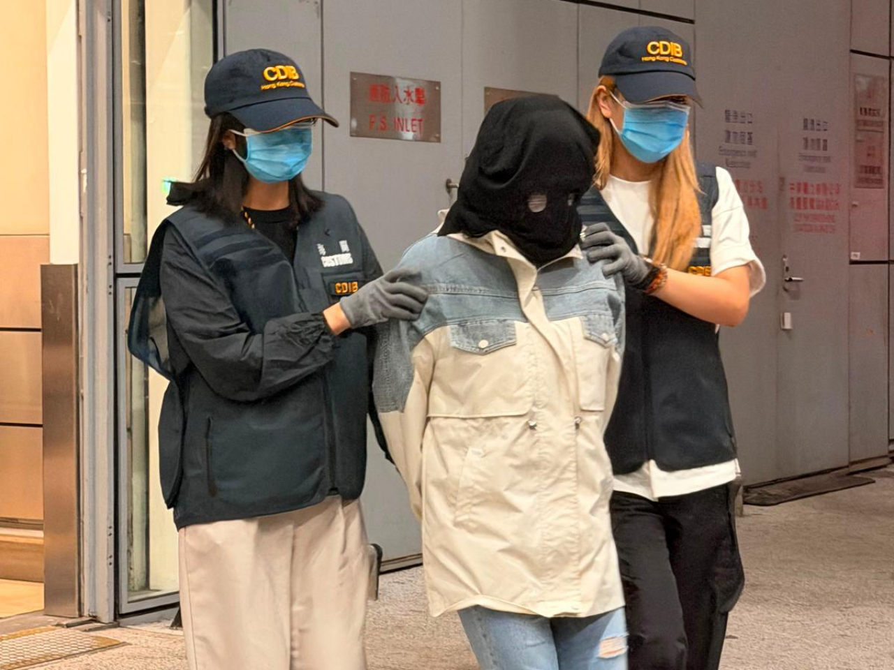 其中一宗案件的被捕人士（中）。（政府新聞處）