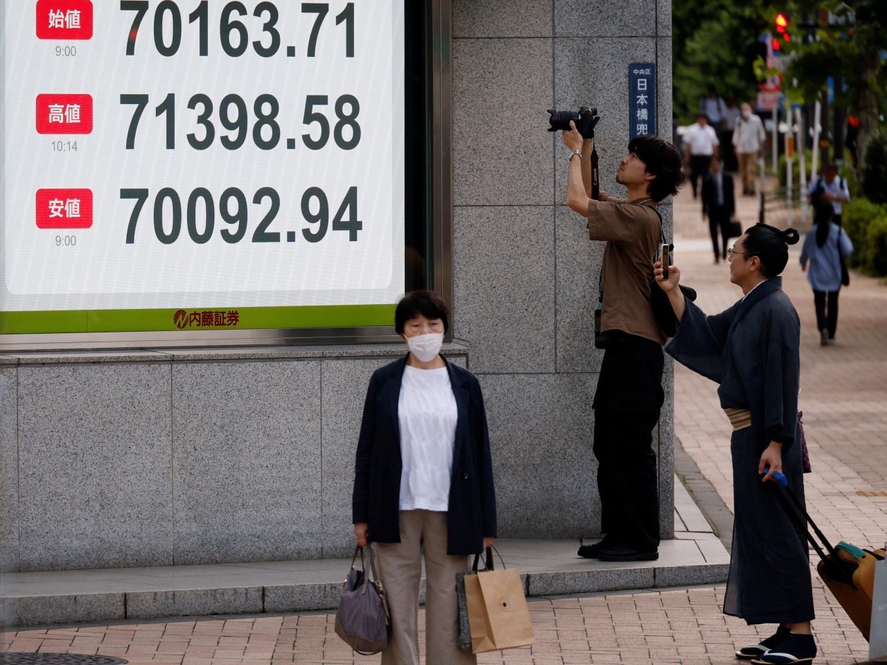 The Nikkei is the focus of interest, with the board showing its opening, its high and its average before it finished at 71,053. Photo: Reuters