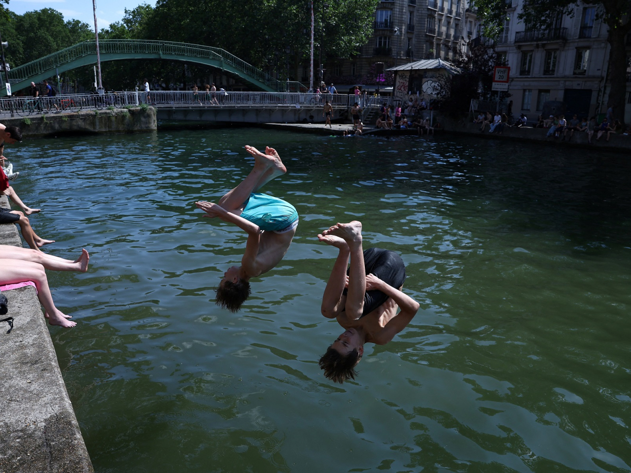 Boys jump into the Canal Saint-Martin as temperatures soared in Paris. Photo: Reuters