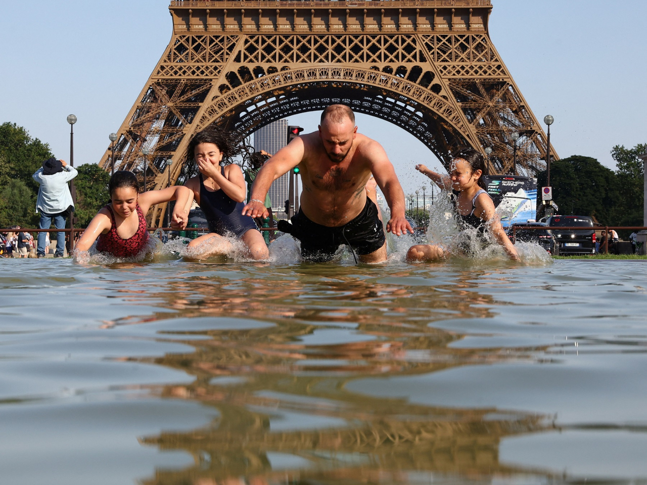 People cool off in the Trocadero Fountain next to the Eiffel Tower in Paris as temperatures rise. Photo: Reuters