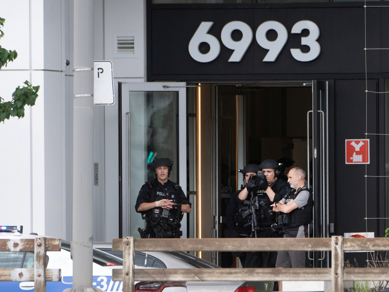 Police officers stand at the entrance to a building after a fatal shooting in the Cote-des-Neiges neighbourhood of Montreal. Photo: Reuters