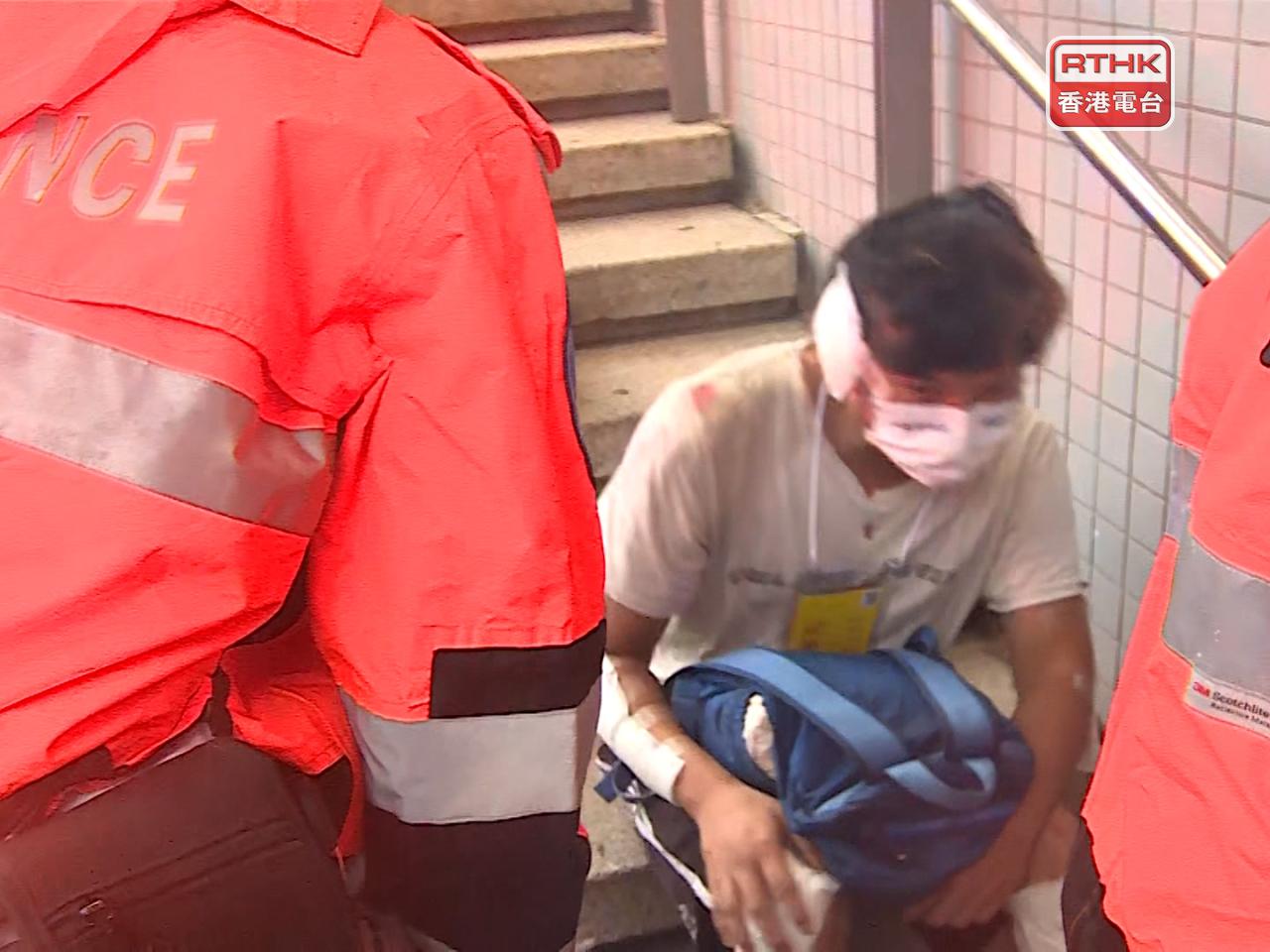 事發後有傷者坐在樓梯接受治療。(張連登攝)
