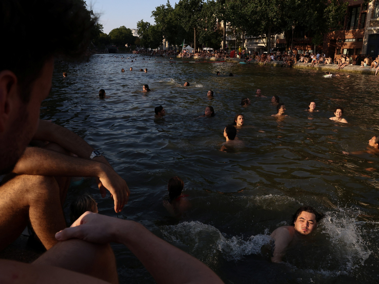 Parisians seek refuge from the heat in the Canal Saint-Martin. Photo: Reuters