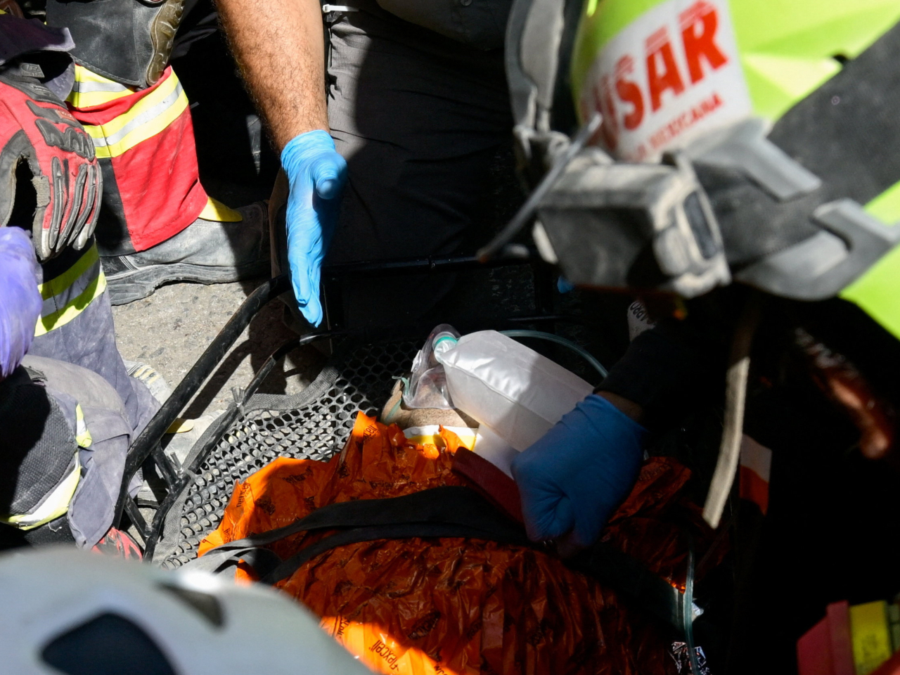 Rescue workers assist survivor Hernan Gil, who was trapped for over a week at a collapsed shopping mall in La Guaira. Photo: Reuters