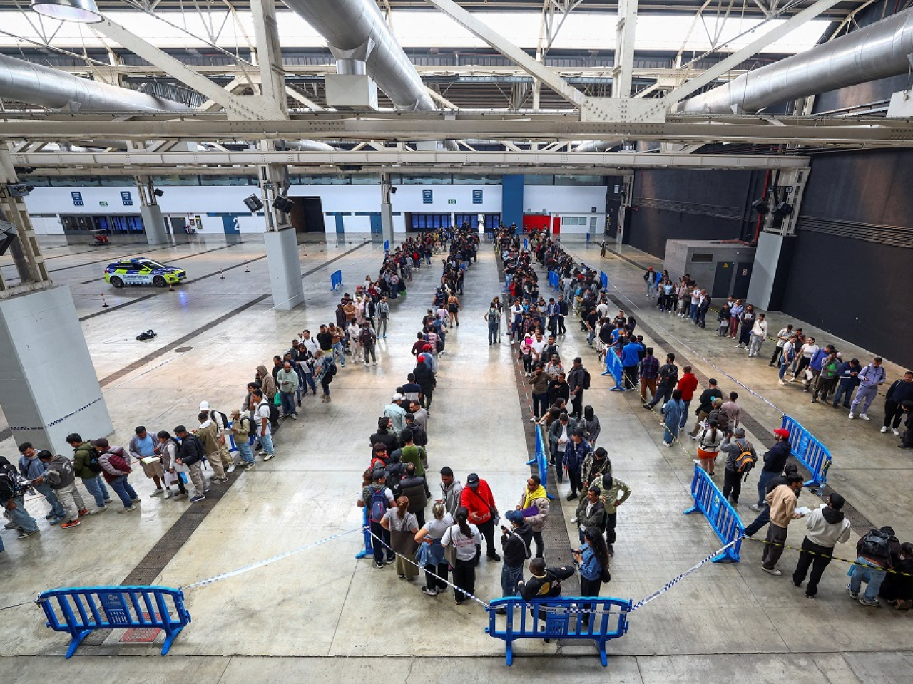 People queue to receive documentation for Spain's mass migrant regularisation process. File photo: Reuters