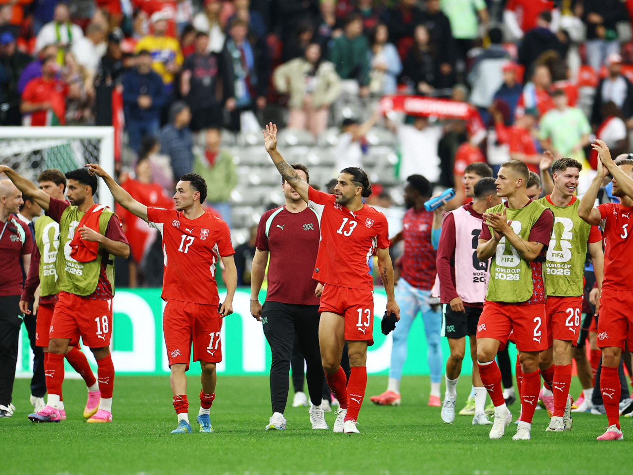 Switzerland's Ricardo Rodriguez and Ruben Vargas celebrate after the match with teammates. Photo: Reuters