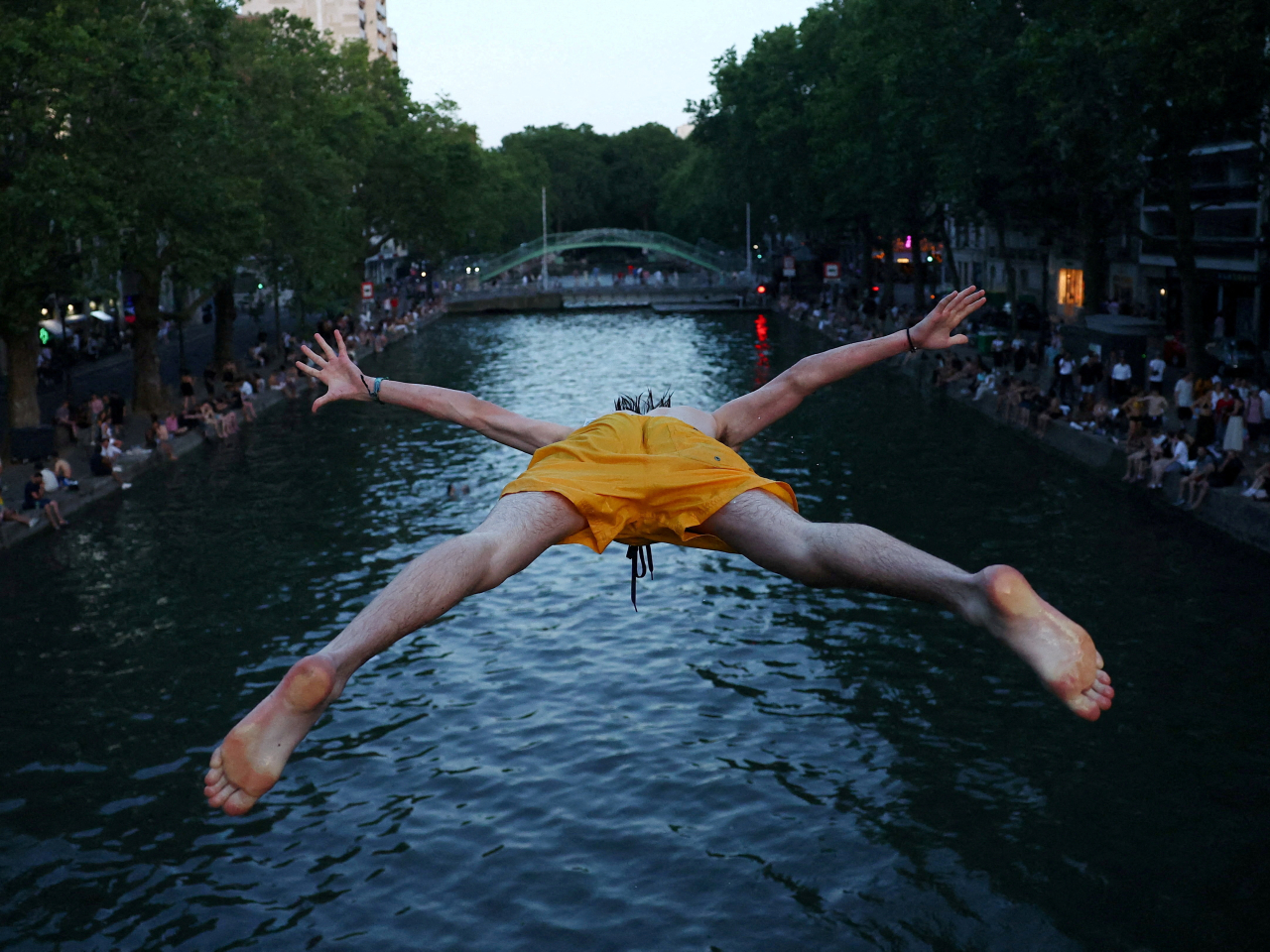 A man goes in for a full-throated dive into the Canal Saint-Martin during a heatwave in Paris. File photo: Reuters