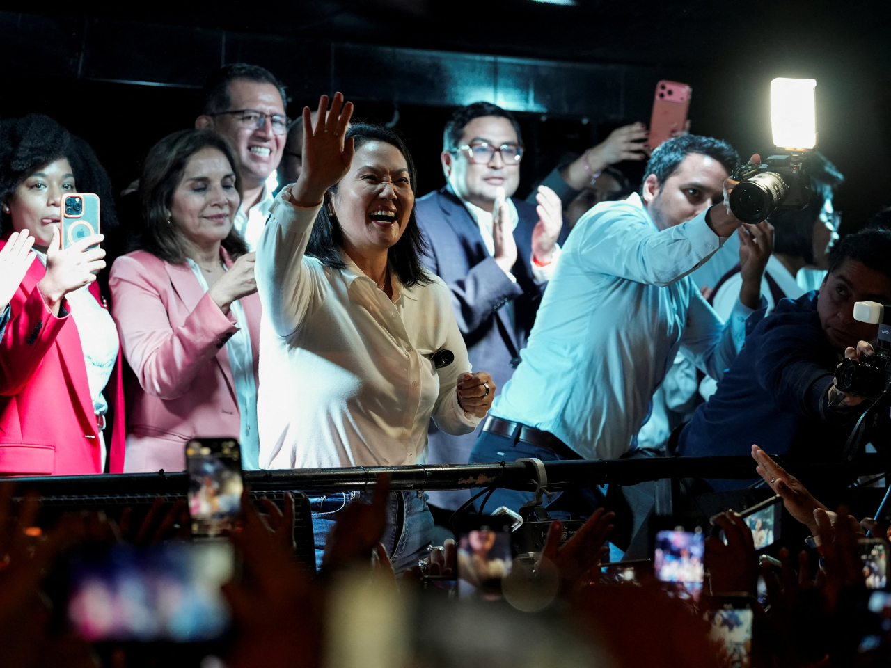 Keiko Fujimori is seen waving to supporters on a TV screen outside her party headquarters in Lima after being declared the winner. Photo: Reuters