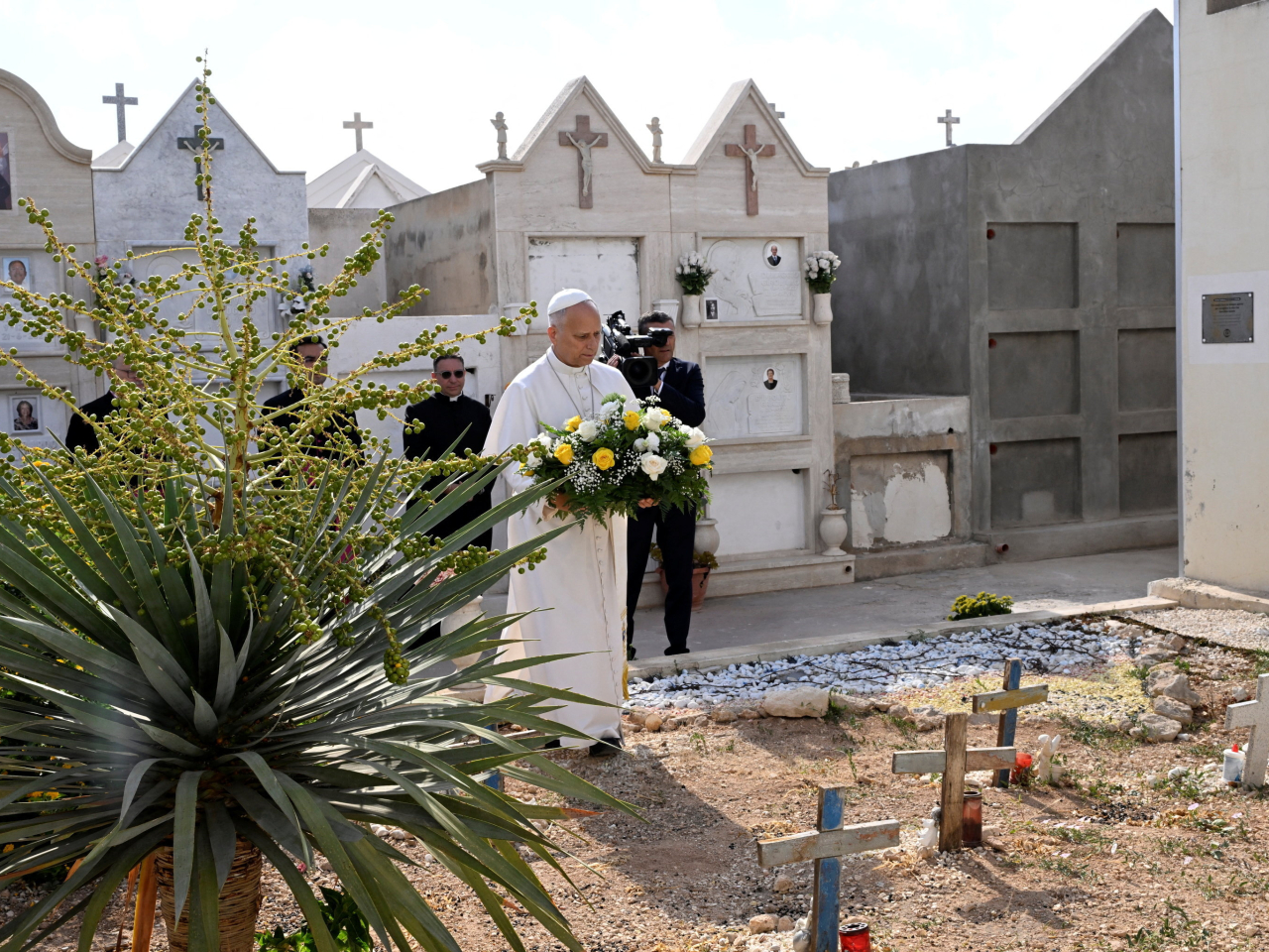 Pope Leo prepares to lay flowers at the grave of baby Joussef, who died not long after a migrant dinghy capsized. Photo: Reuters