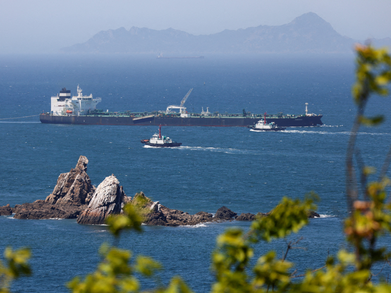 Tugboats guide a South Korea-bound crude oil tanker through the Strait of Hormuz with its transponder turned off. File photo: Reuters