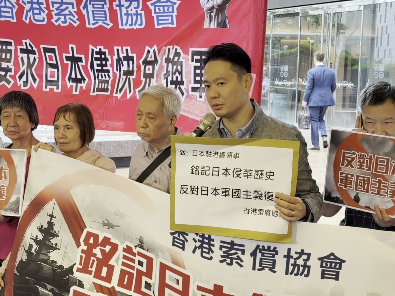 香港索償協會代表聯同民建聯立法會議員周浩鼎，到總領事館所在的中環交易廣場樓下抗議。(實習記者許浚嘉攝 )