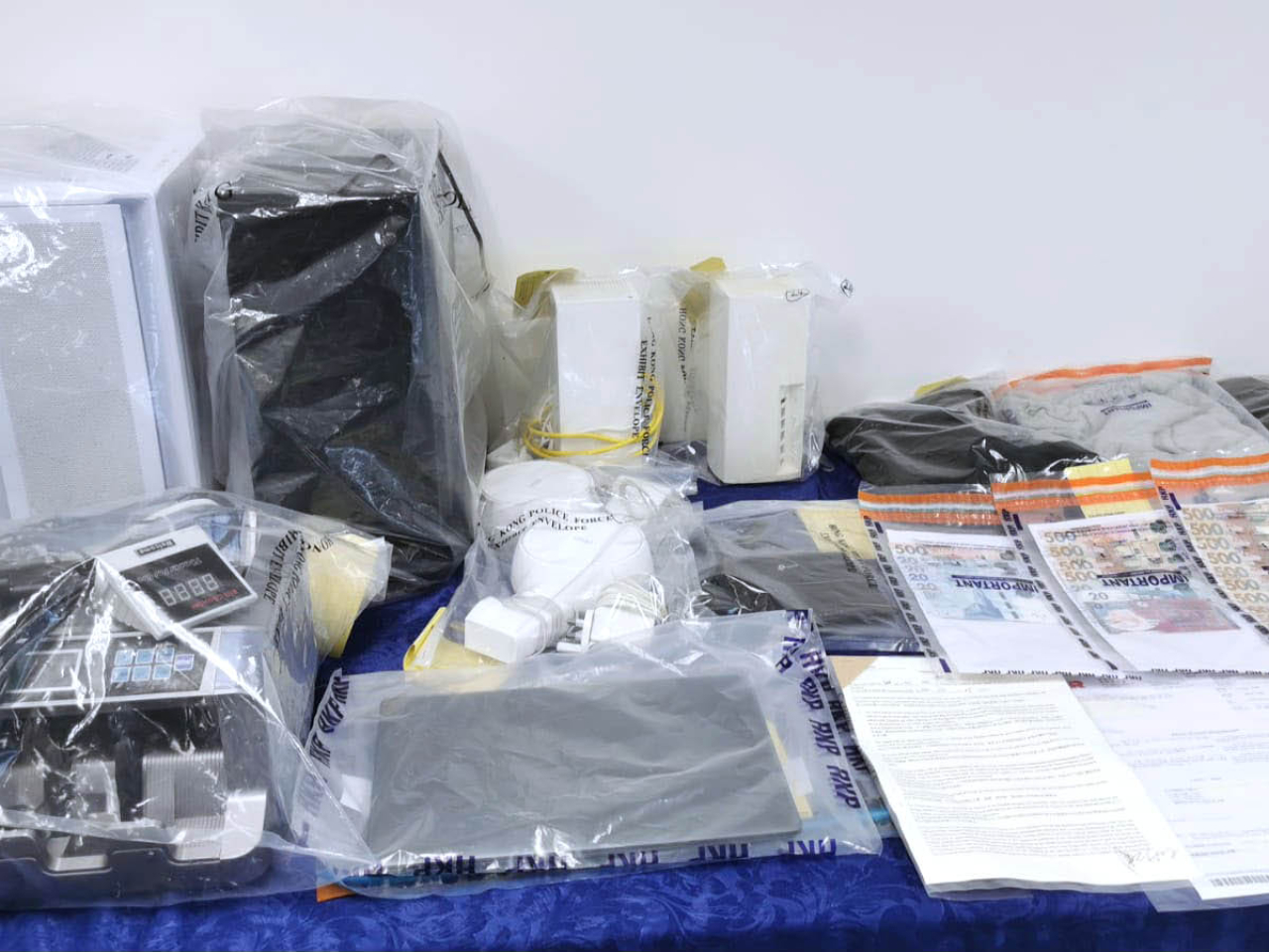 警方在行動中檢獲店鋪內的點鈔機、電腦、手提電話和部分現金。（警方提供）