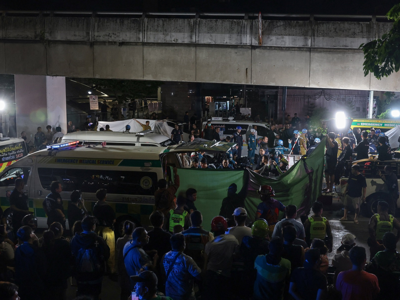 People gather as members of emergency personnel transfer the bodies of deceased people near the site of a deadly fire at a pub in Bangkok. Photo: Reuters