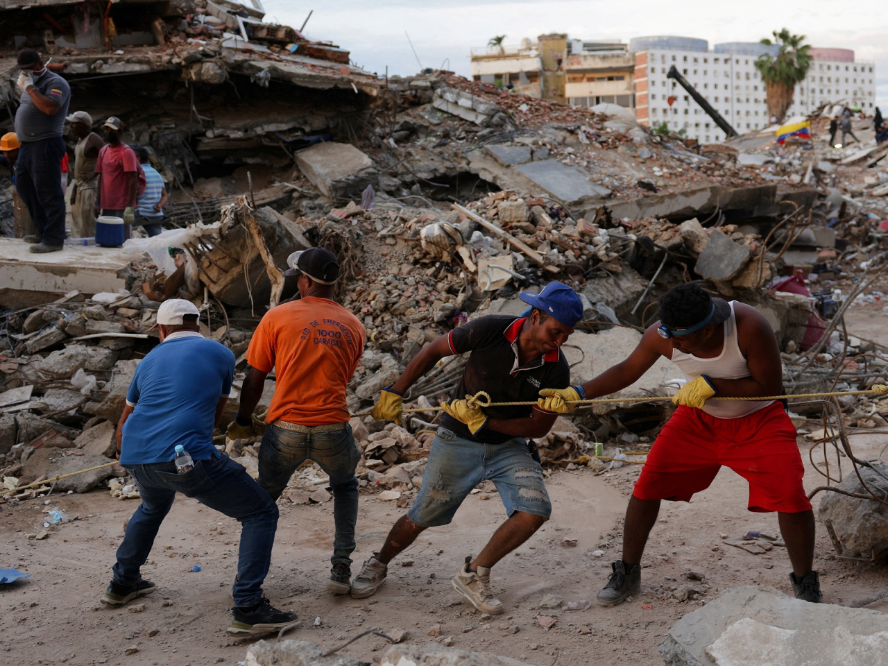 People work together as they search for their loved ones amid the debris in La Guaira, Venezuela. Photo: Reuters