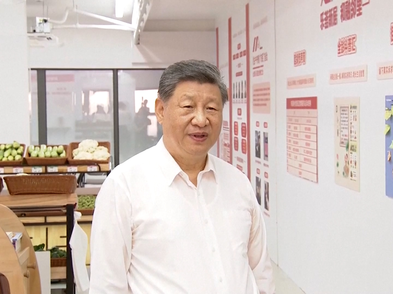 習近平到社區黨群服務站，視察便民菜攤蔬果供應情況。（央視新聞截圖）