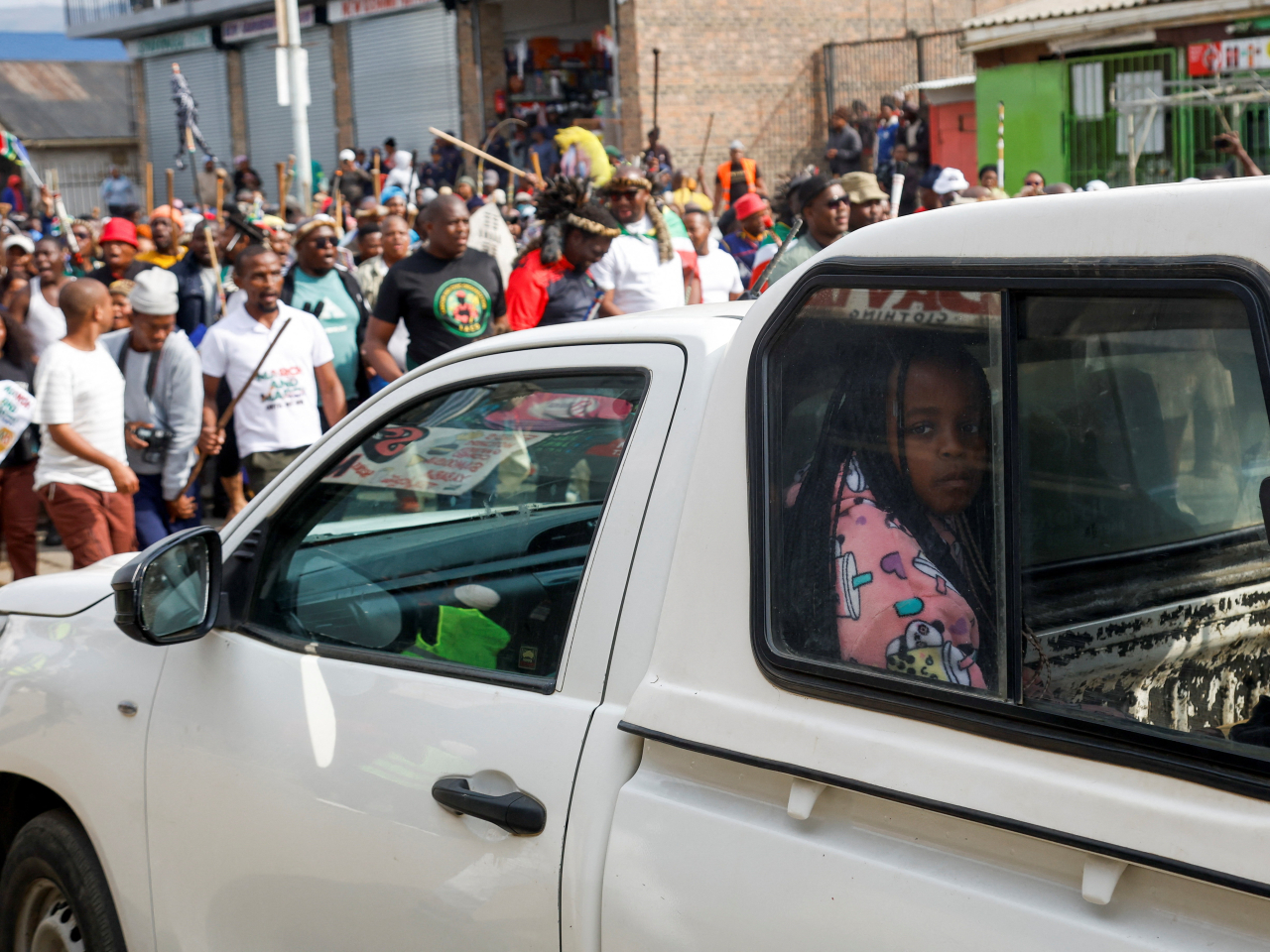 A girl sits in a car as supporters of the South African anti-immigrant group 'March and March' hold a demonstration in Umzimkhulu, South Africa. Photo: Reuters