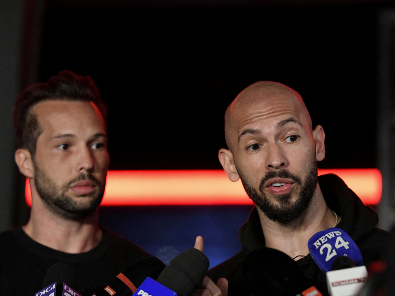Tristan and Andrew Tate deliver a press statement in front of their house after landing back in Romania in March 22, 2025. File photo: Reuters