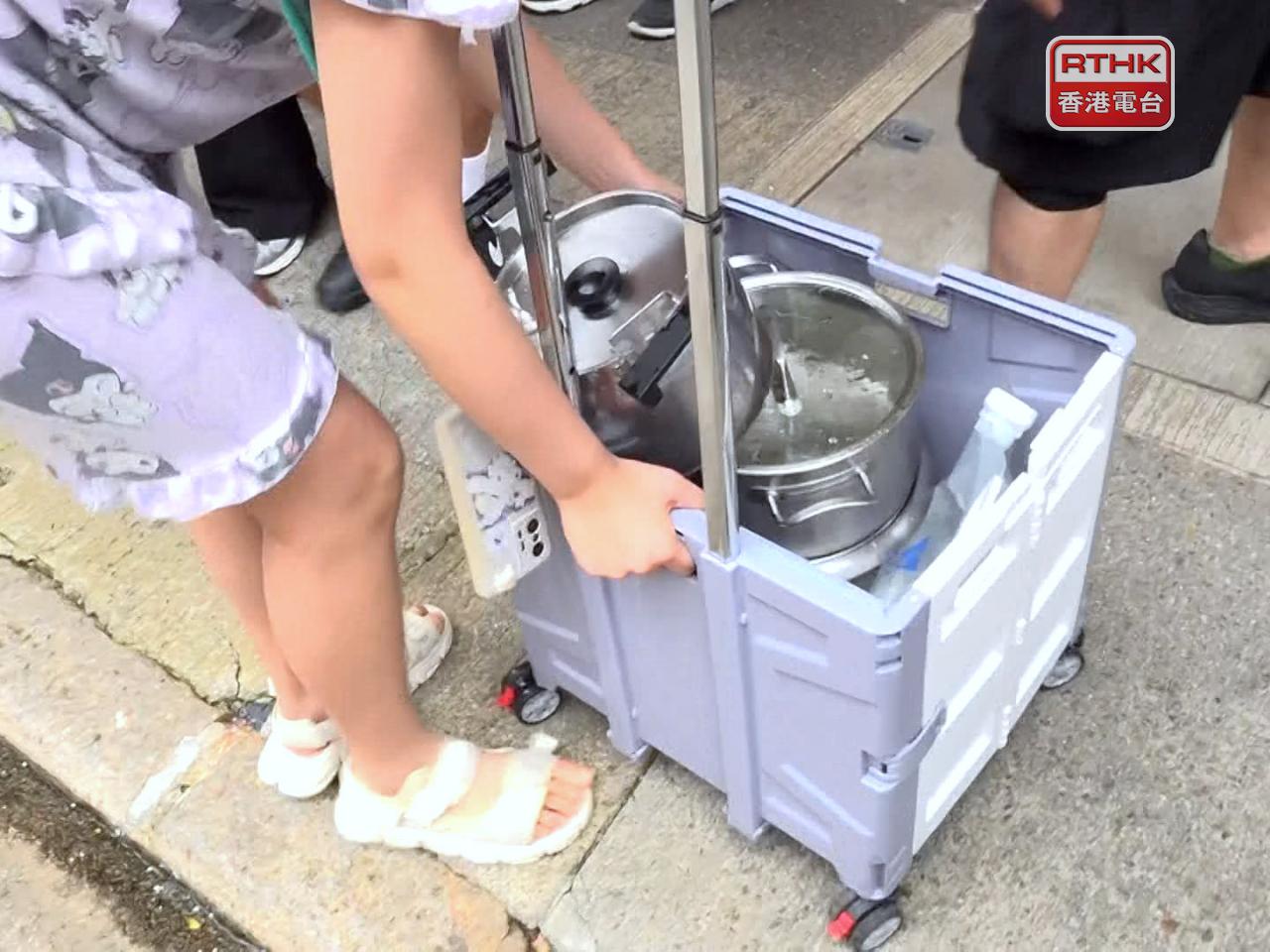 有小朋友帶同購物車和多個水煲取水。（郭志強攝）