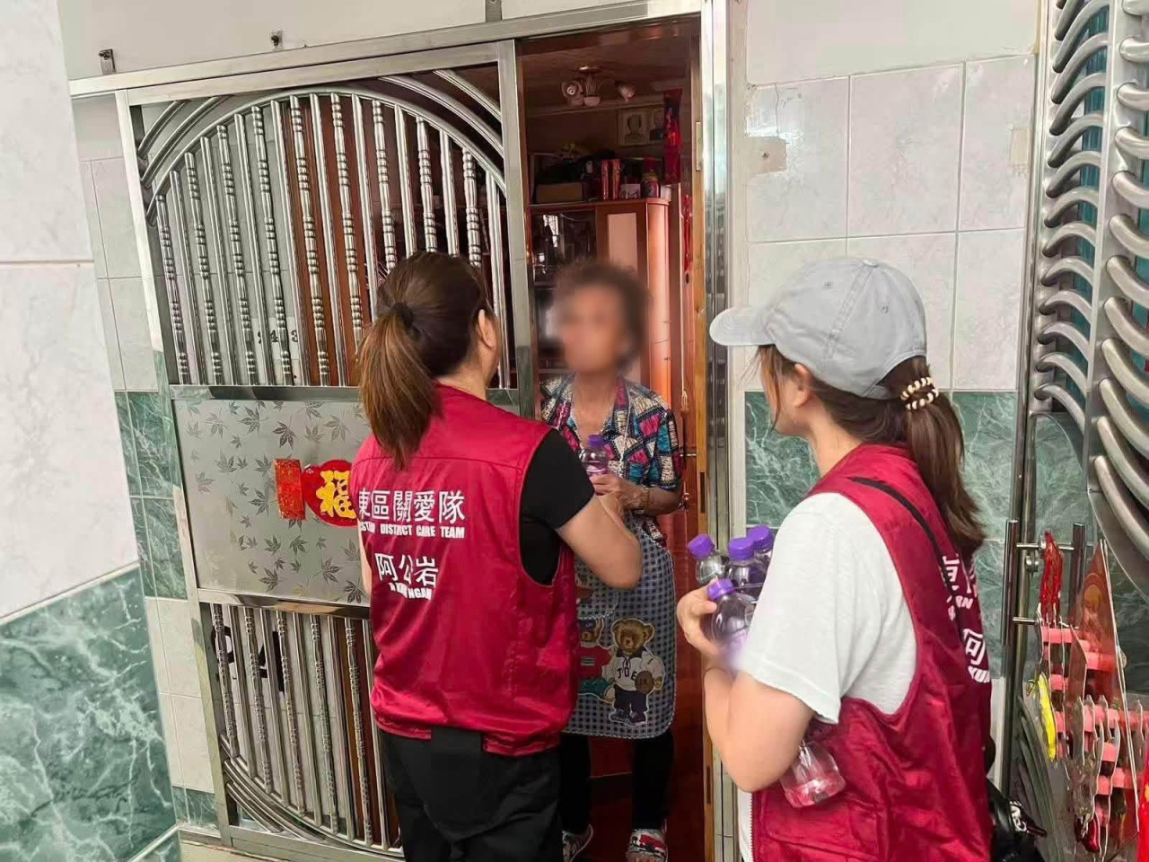 關愛隊上樓派發樽裝水給受影響居民。（民政事務總署相片）