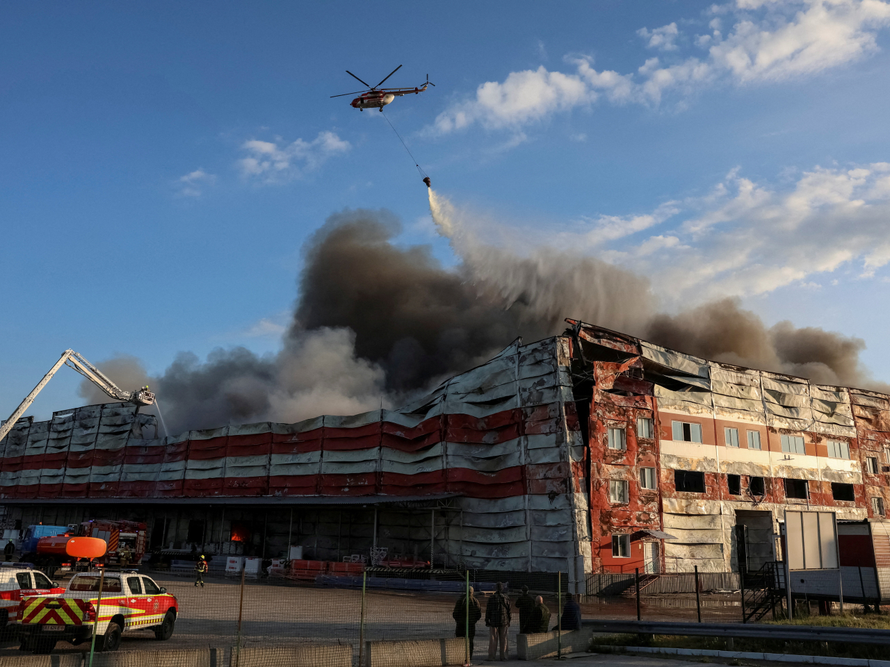 A firefighting helicopter drops water over the site of a Russian missile strike. Photo: Reuters
