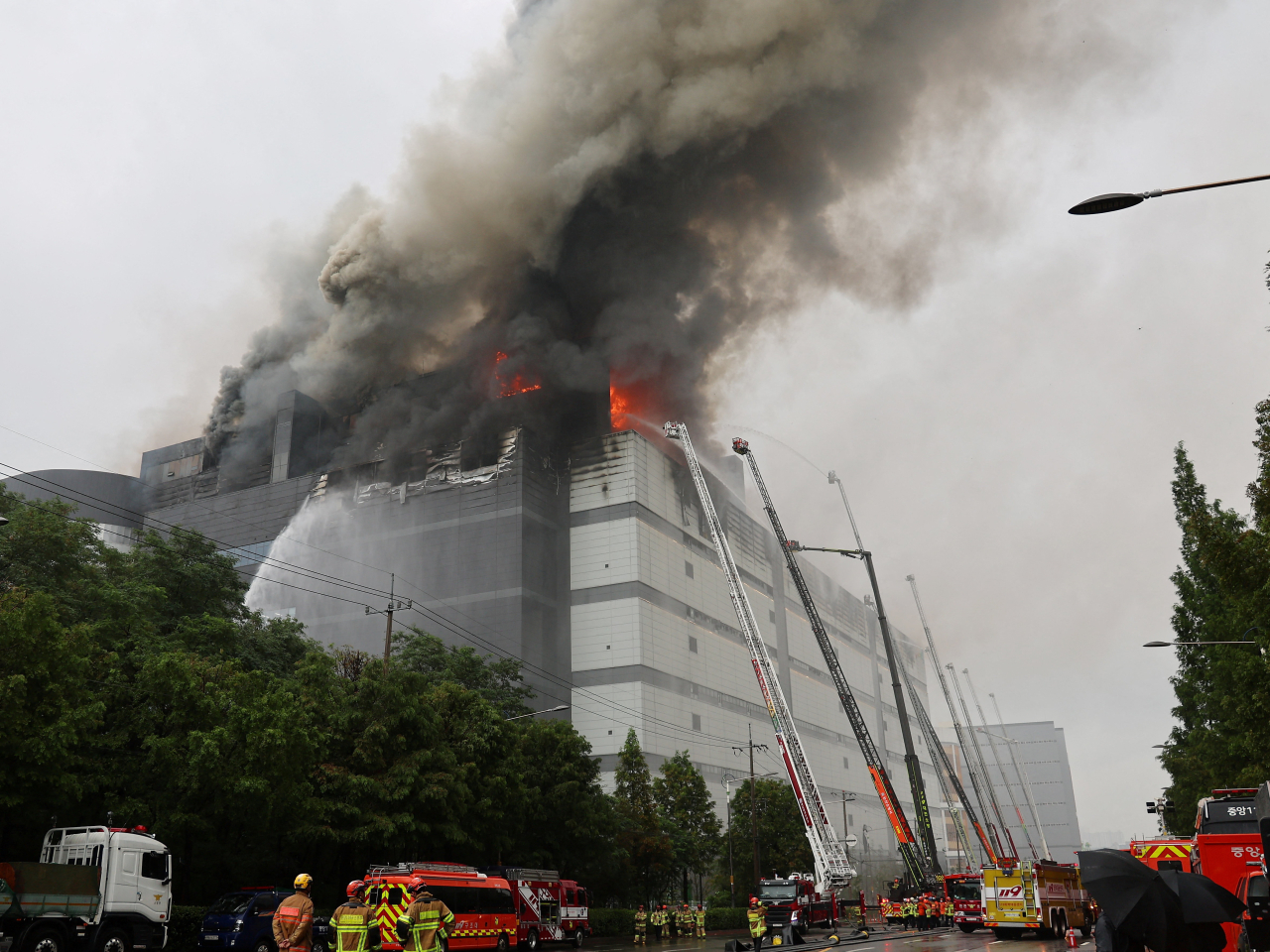 Firefighters tame the Coupang blaze amid rain. Photo: Reuters