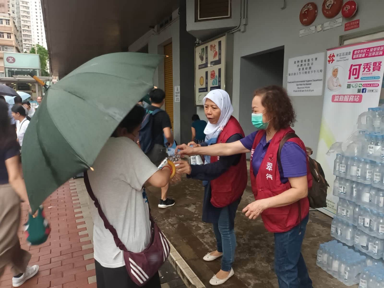 區議員及關愛隊今早繼續出動，在取水點協助居民。（民政事務總署）