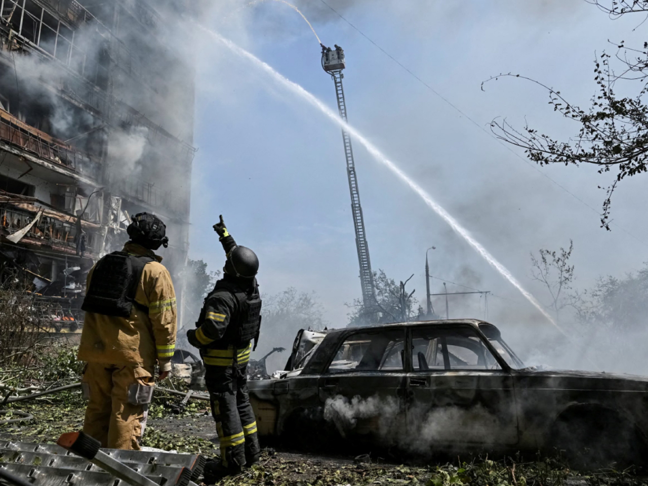 烏克蘭扎波羅熱一座建築物遭受空襲，引發火警，消防人員到場撲救。（路透社）
