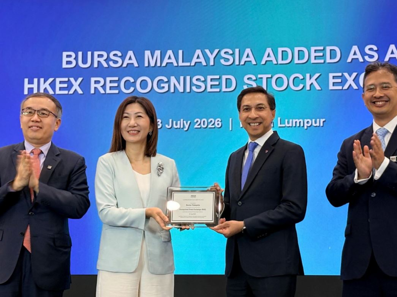 Bonnie Chan presents a certificate to Dato' Fad'l Mohamed after the HKEX announced the Malaysian stock exchange had become a recognised stock exchange. Photo courtesy of Information Services Department