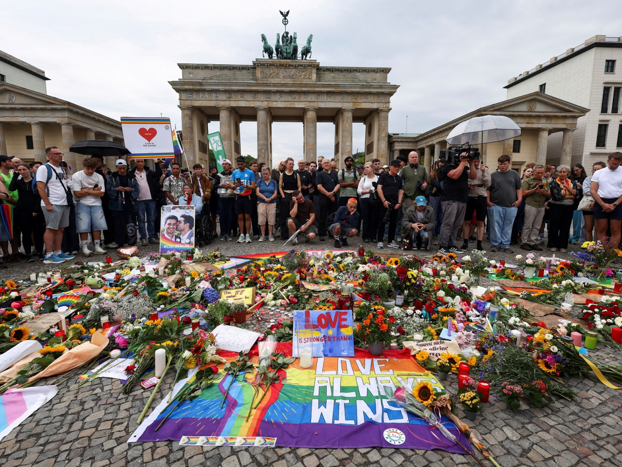 People gather around flowers, mementos and candles left by people at the Brandenburg Gate following the deadly attack. Photo: Reuters