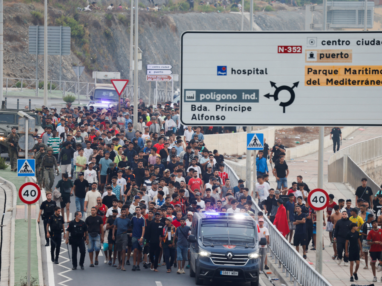 Spanish police and soldiers shepherd migrants to take them out of Spanish territory. Photo: Reuters