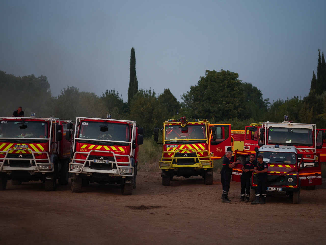 Firefighters stand by their fire engines as they battle a wildfire near Montfort-sur-Argens in the Var department. Photo: Reuters