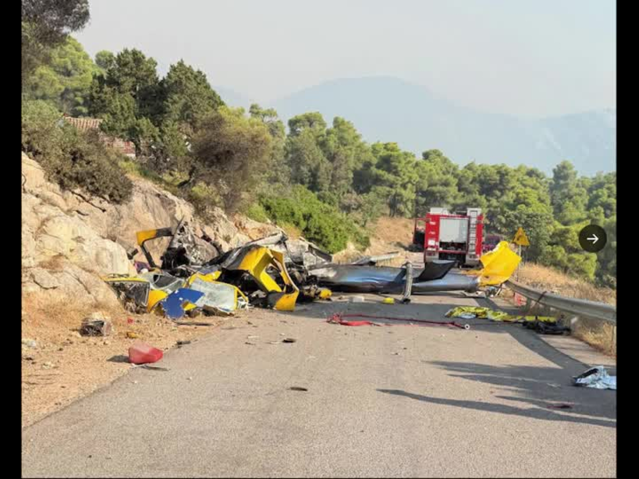A photograph released by the Hellenic Red Cross show a crashed firefighting helicopter after two helicopters collided while battling a wildfire in the area of Psatha in the Attica region. Image: Hellenic Red Cross via Reuters