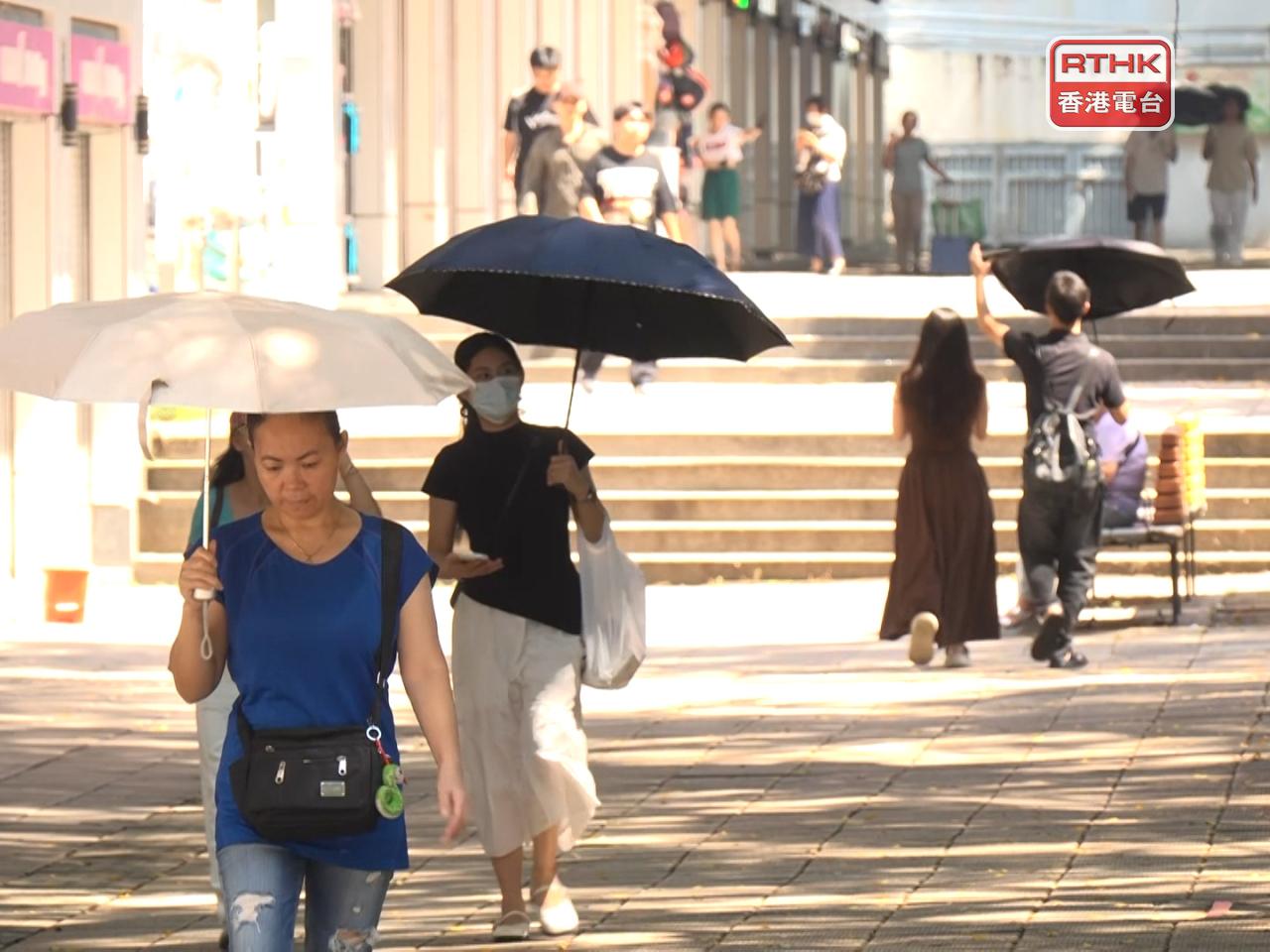 酷熱天氣下，市民舉傘遮擋陽光。（鍾家銘攝）