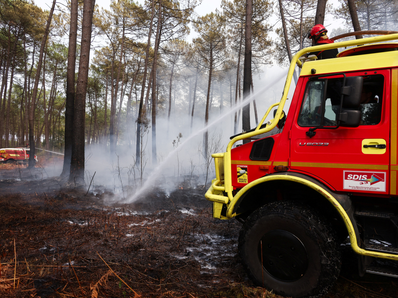 A firefiighter shoots a jet of water at a hotspot in a forest close to Bordeaux, Gironde amid worsening conditions. Photo: Reuters