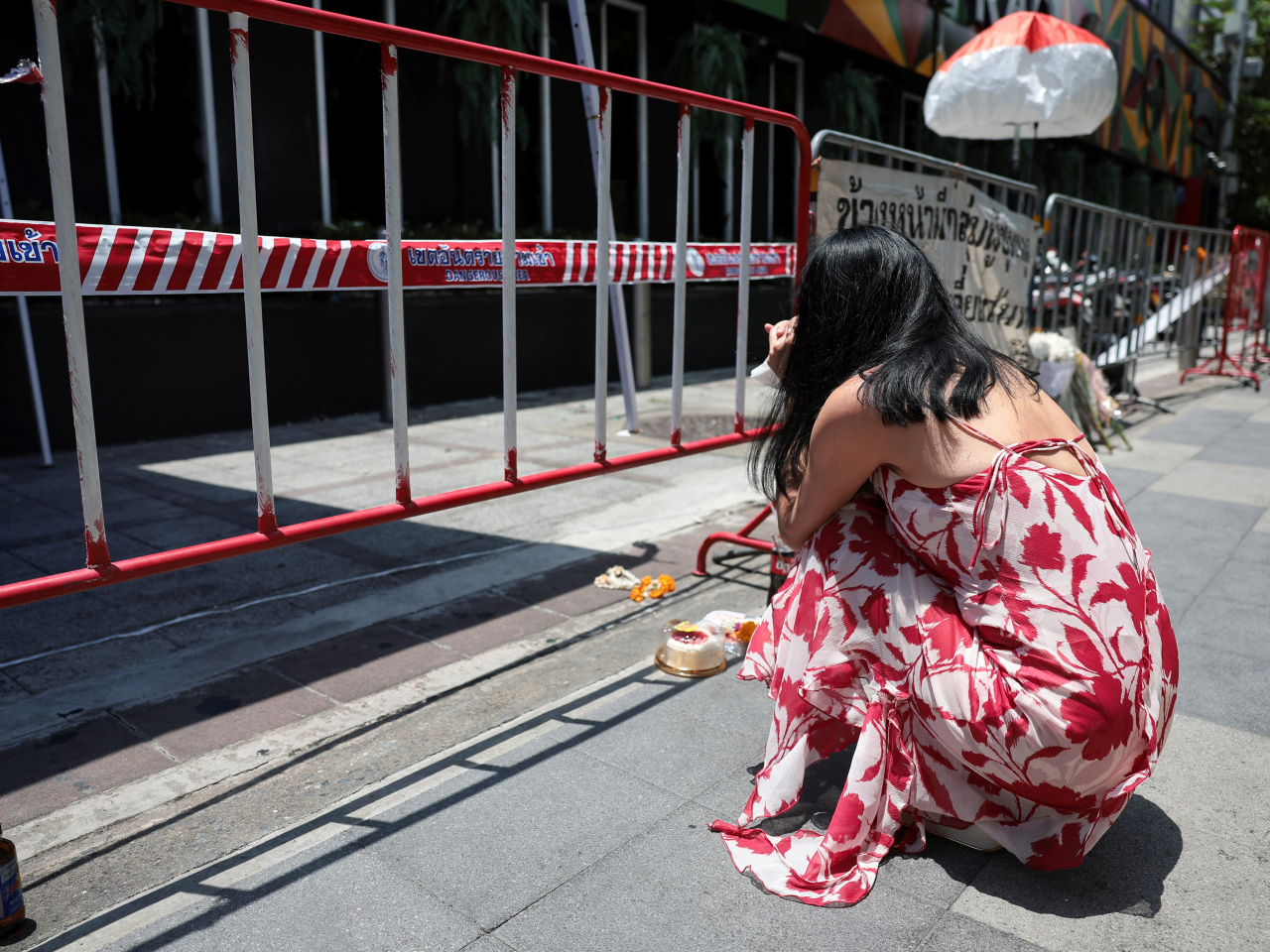 A woman mourns the dead outside the remains of Rong Beer Na Lat Phrao bar in Bangkok. File photo: Reuters