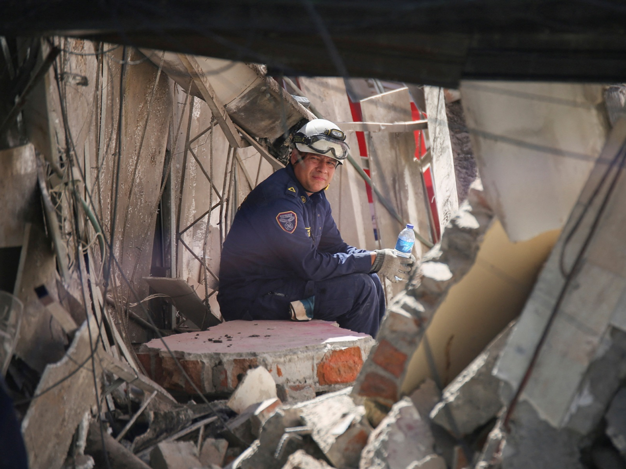 A firefighter takes a break inside a collapsed building in Dosquebradas. Photo: Reuters