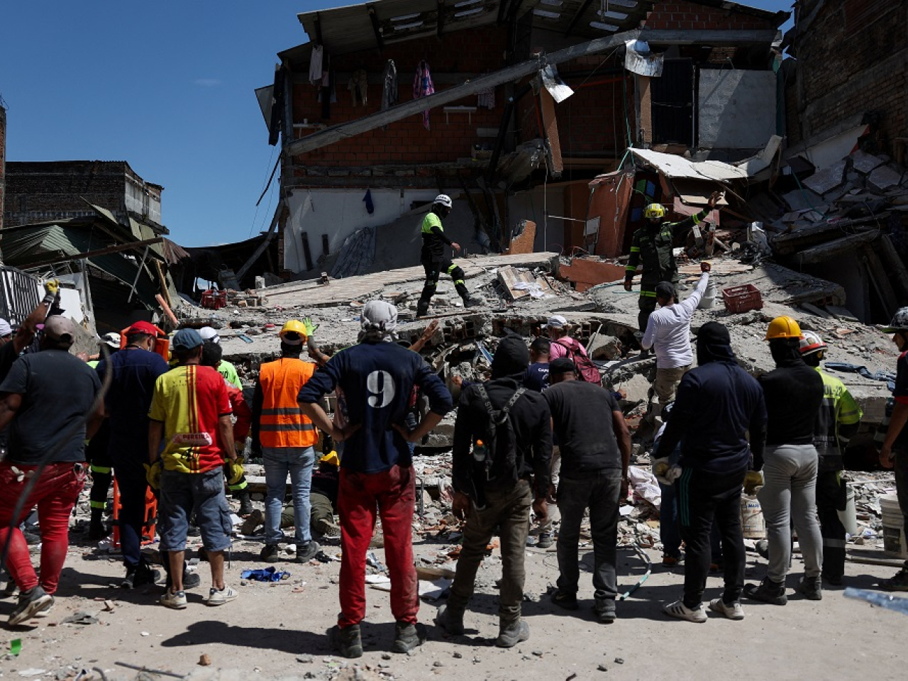 Rescue workers call for silence as they search for signs of life under the rubble in Pereira. Photo: Reuters