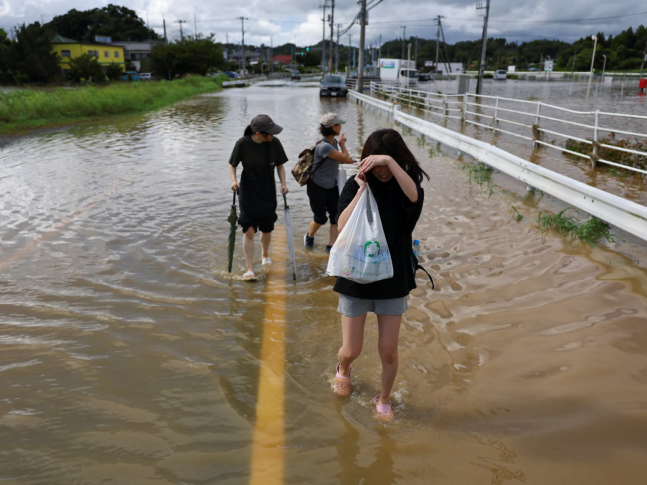 在千葉縣大網白里市，居民在積水區域行走。（路透社）