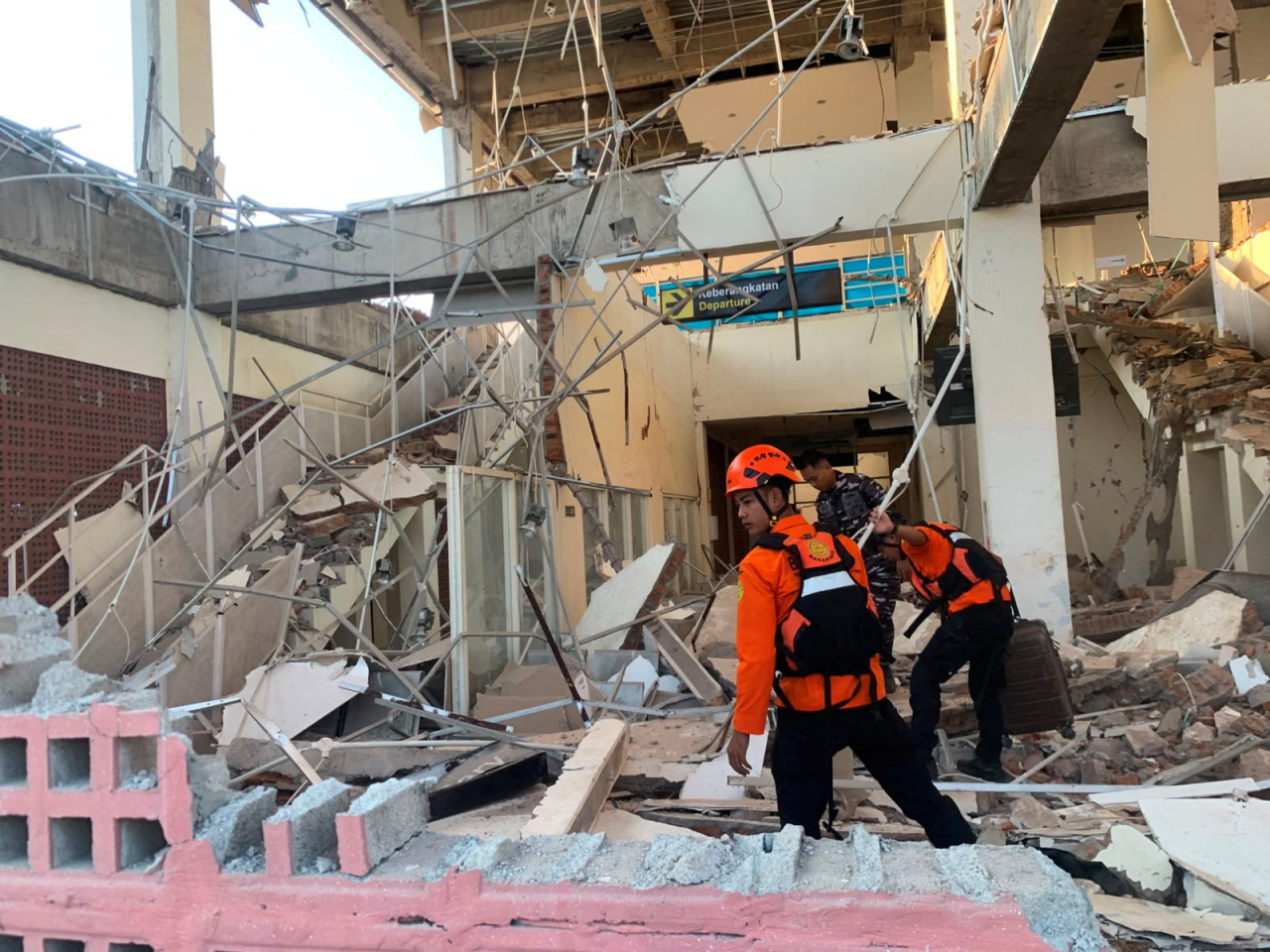 A rescuer treads carefully through a building in Laurentius Say port in Maumere in search of survivors. Photo: Reuters