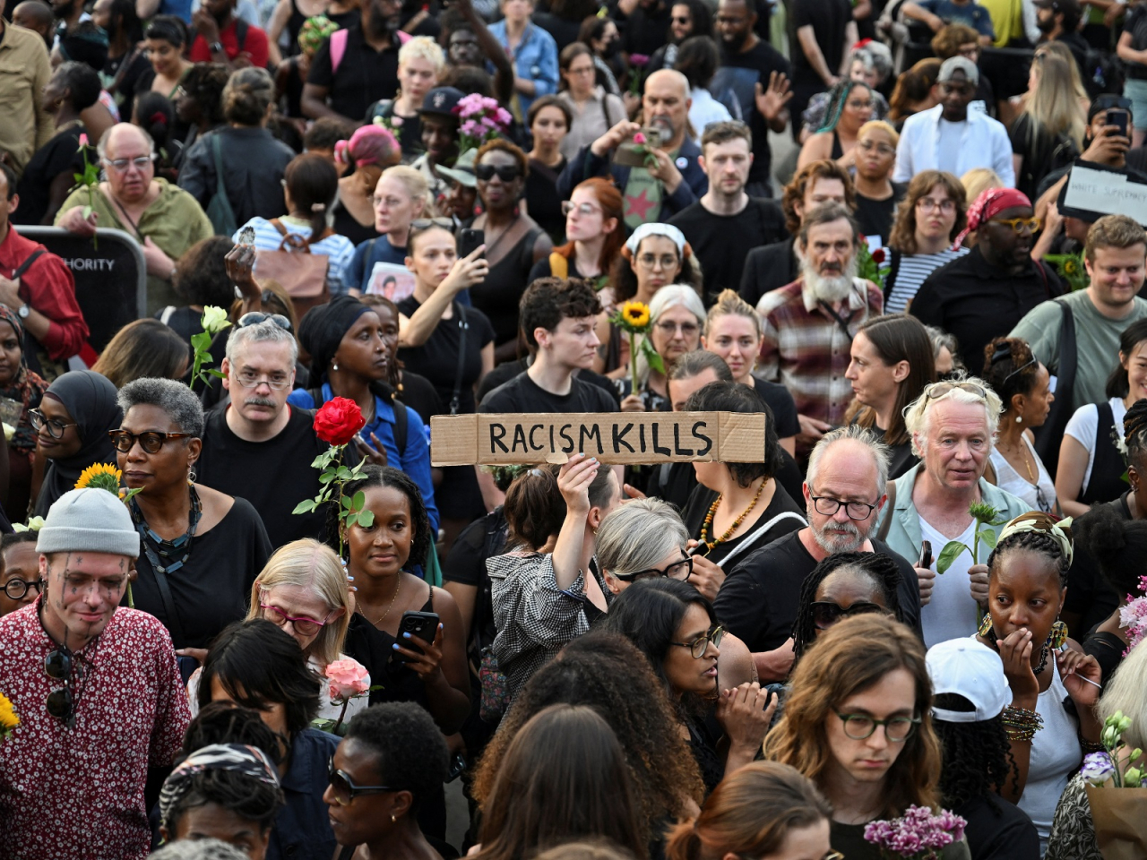 A mourner holds up an anti-racism sign at a vigil at Trafalgar Square in London to remember former Cambridge professor Jason Arday. Photo: Reuters