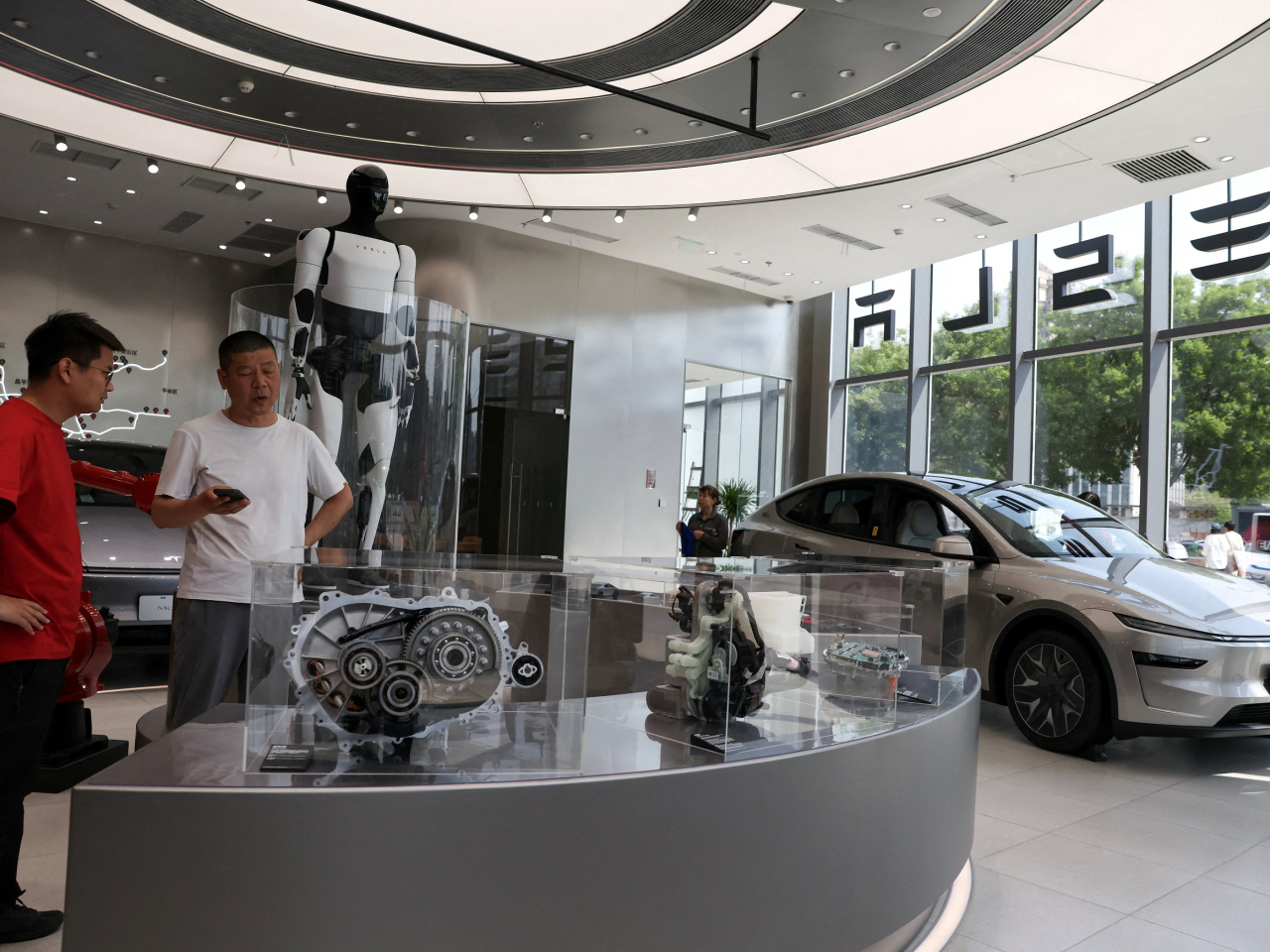 A staff member attends to a customer inside a Tesla store at a shopping mall in Beijing. Tesla is one of 11 carmakers that launched software updates and vehicle recalls on Friday. File photo: Reuters