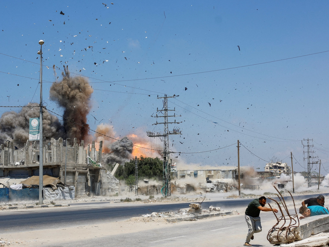 People run for cover during an Israeli strike on Zawayda town in the central Gaza Strip. Photo: Reuters
