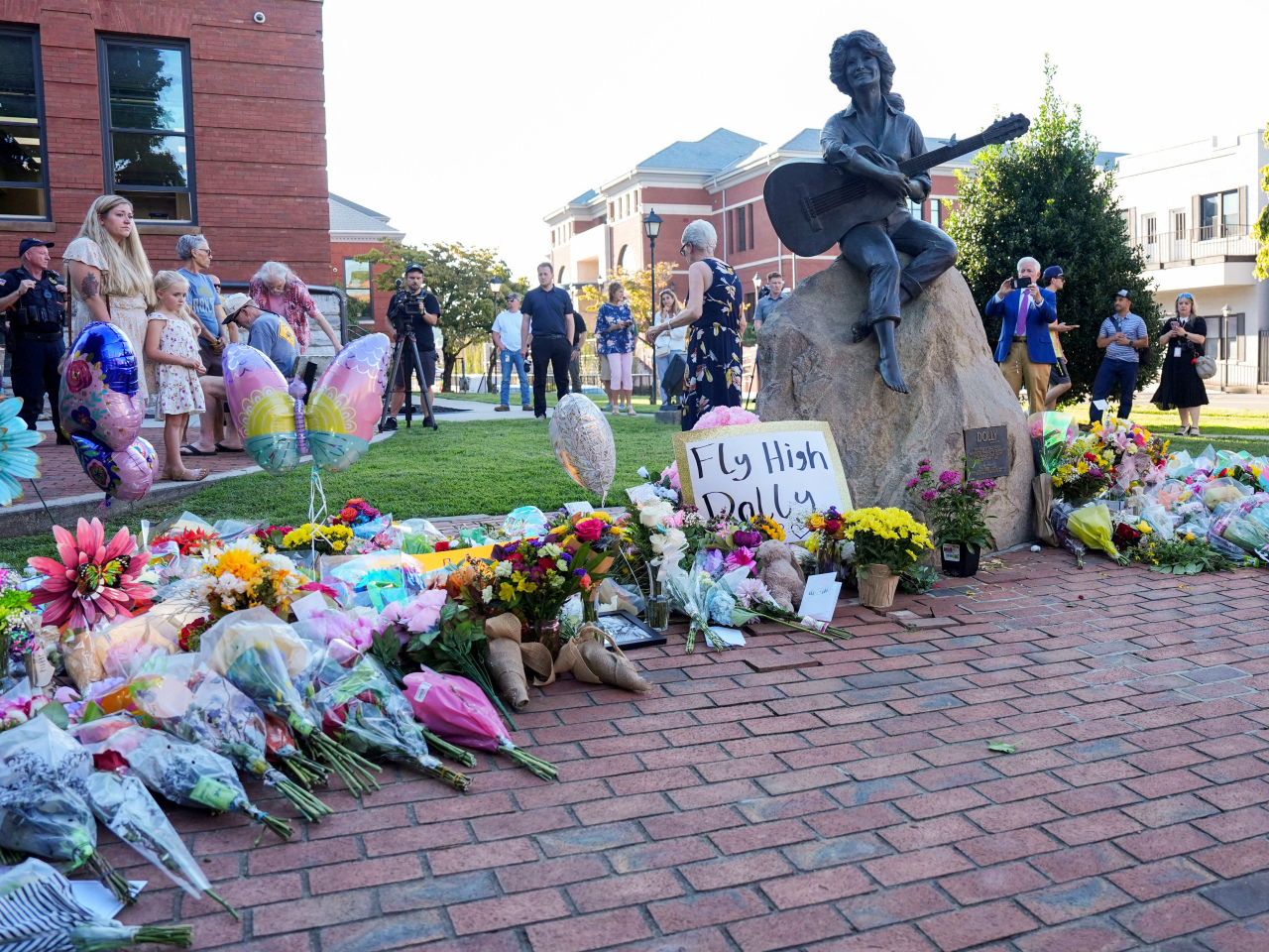 Mourners in Sevierville, Tennessee, near where Dolly Parton grew up, pay their respects at a statue dedicated to her. Photo: Reuters via USA Today Network