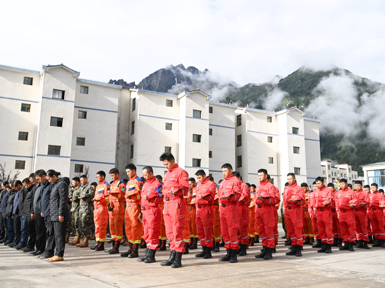 Rescuers, local officials and residents stand in silence during a memorial service in Gyirong county, Shigatse, for victims of the August 26 mudslide. Photo: cnsphoto via Reuters