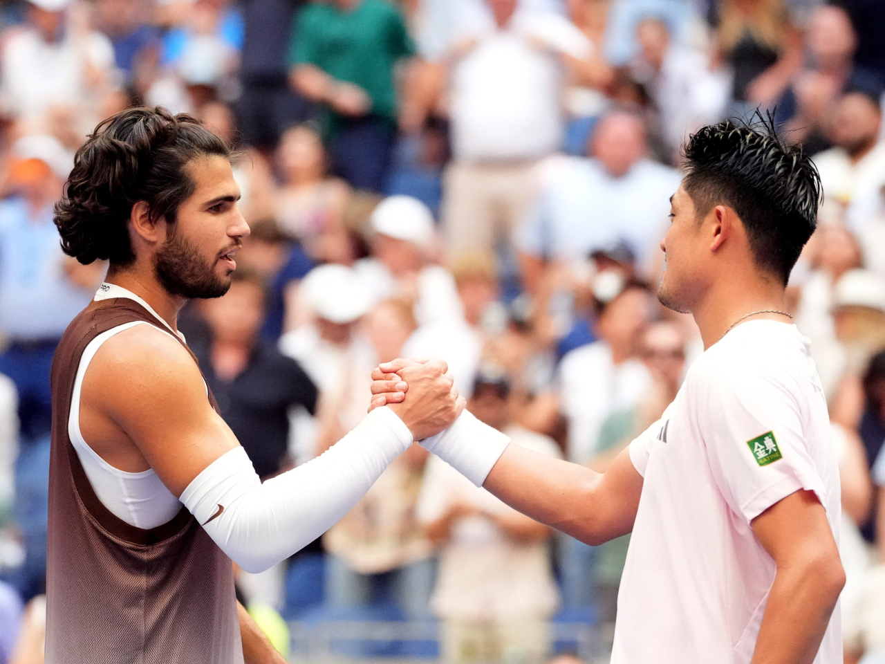 Carlos Alcaraz and Wu Yibing shake at the net after their third-round match in Flushing Meadows. Photo: Imagn Images via Reuters