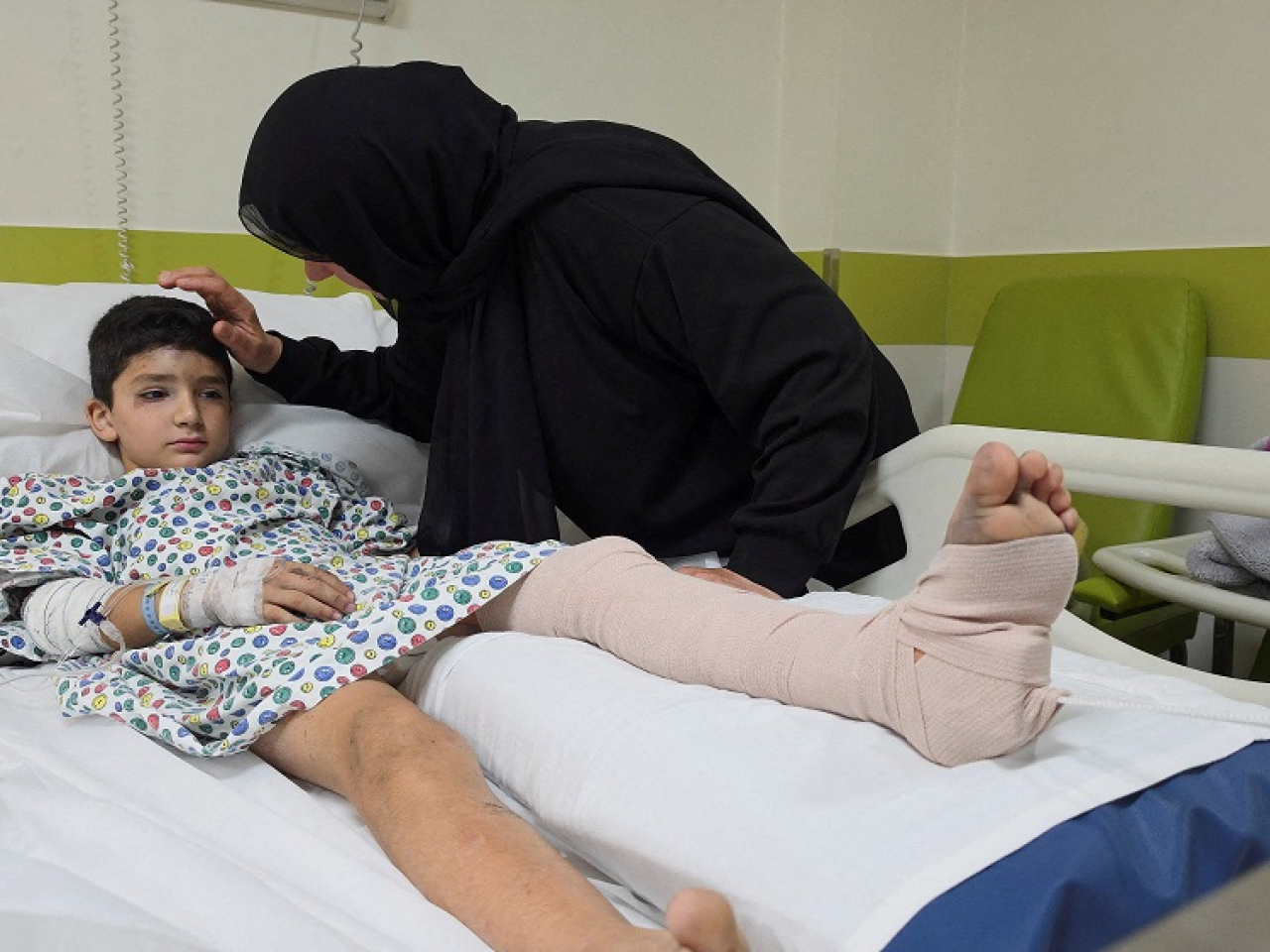 Eight-year-old Mustafa Farhat is comforted by a relative after being wounded in one of the Israeli air strikes. Photo: Reuters