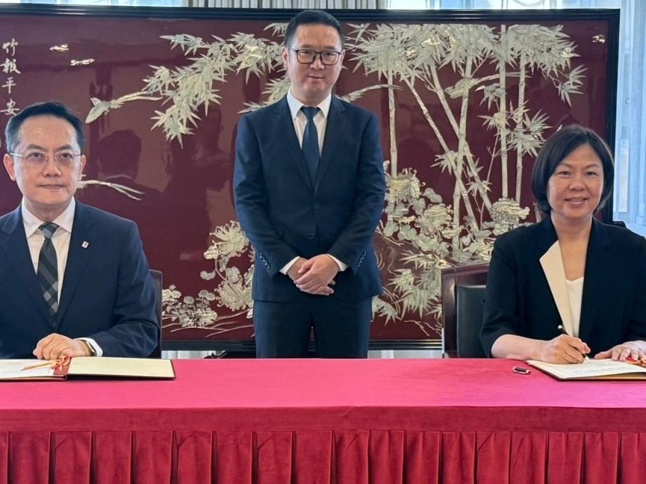 林文健（左）與藥監局港澳台辦公室主任何莉（右）在藥監局局長黃果（中）見證下簽署《關於中藥檢測及標準研究領域的合作安排》。(政府新聞處)