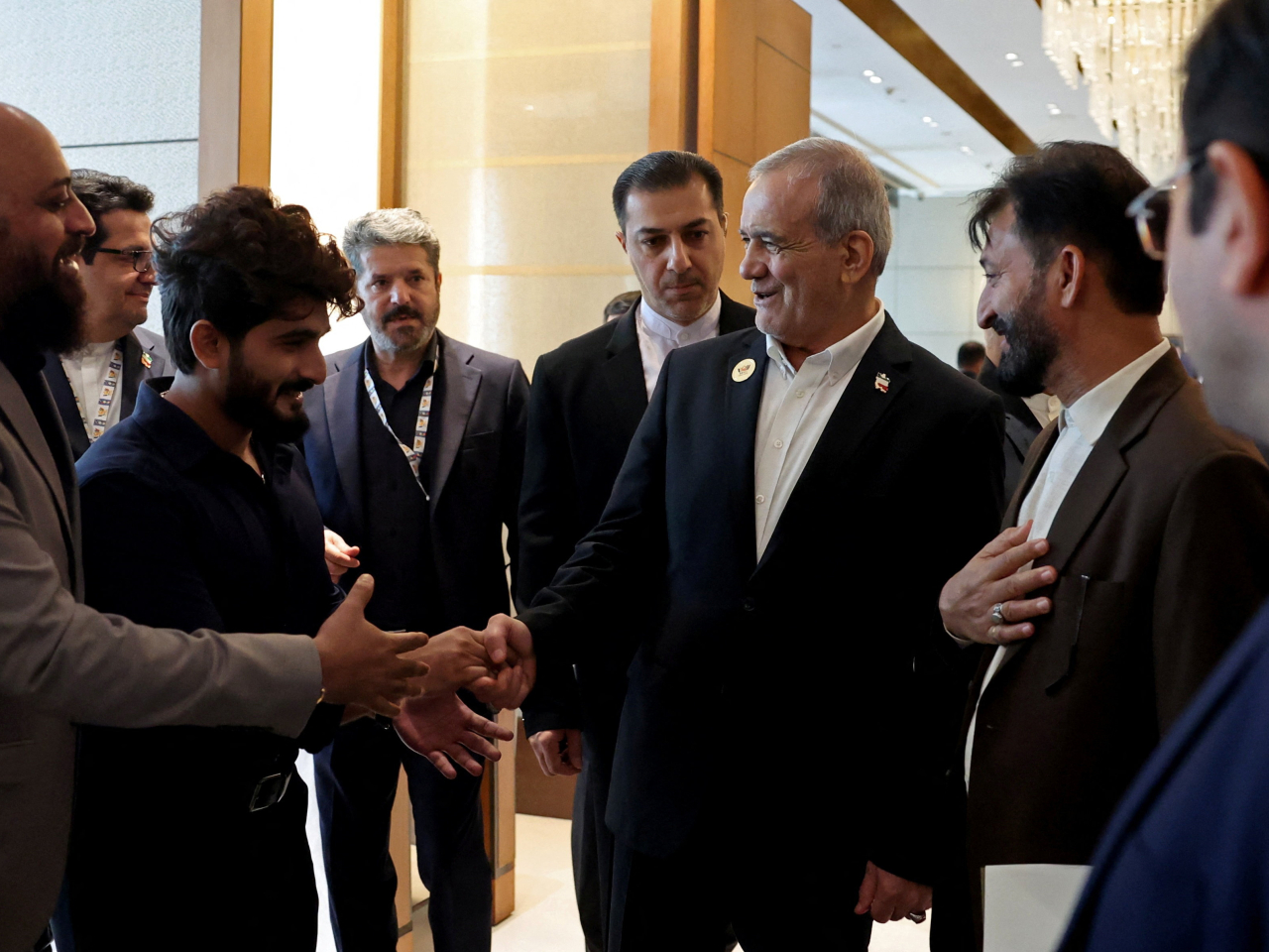 Iranian President Masoud Pezeshkian is greeted as he walks inside a hotel in New Delhi. Photo: Reuters